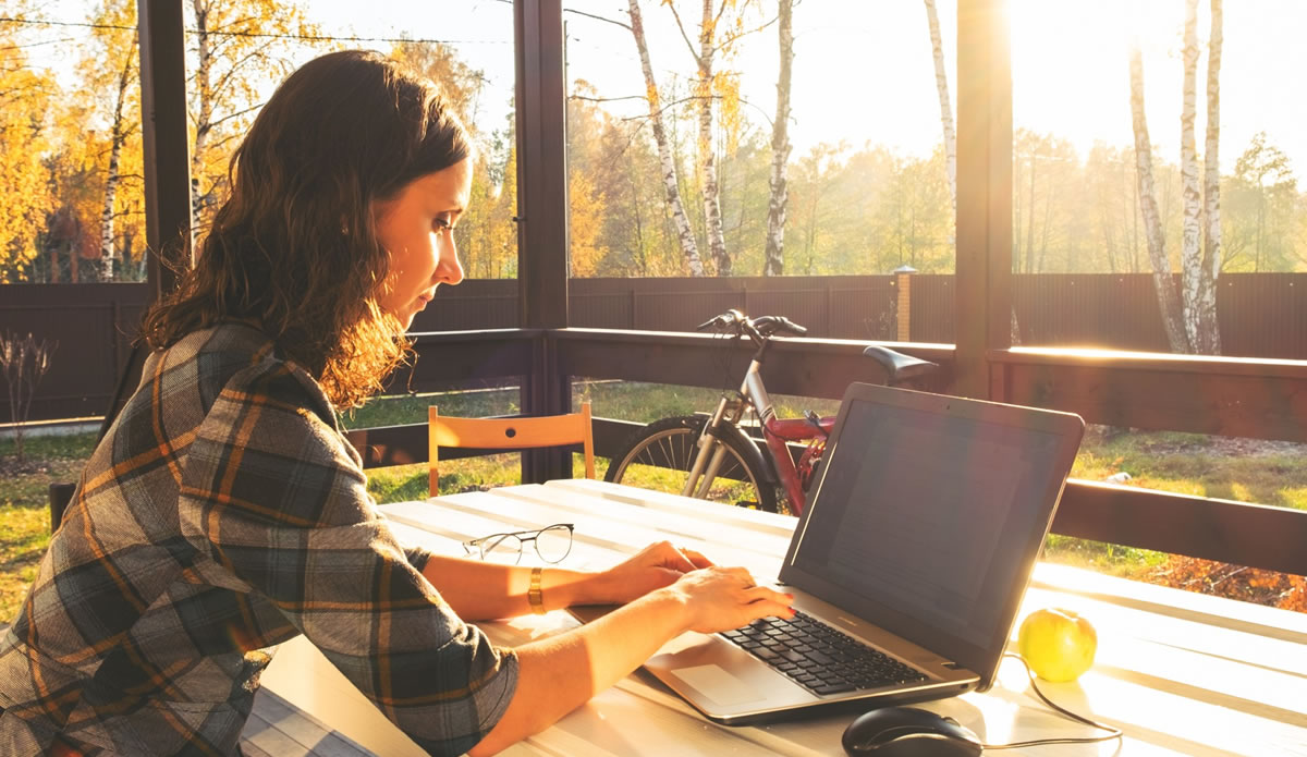 Businesswoman writing on laptop from home office