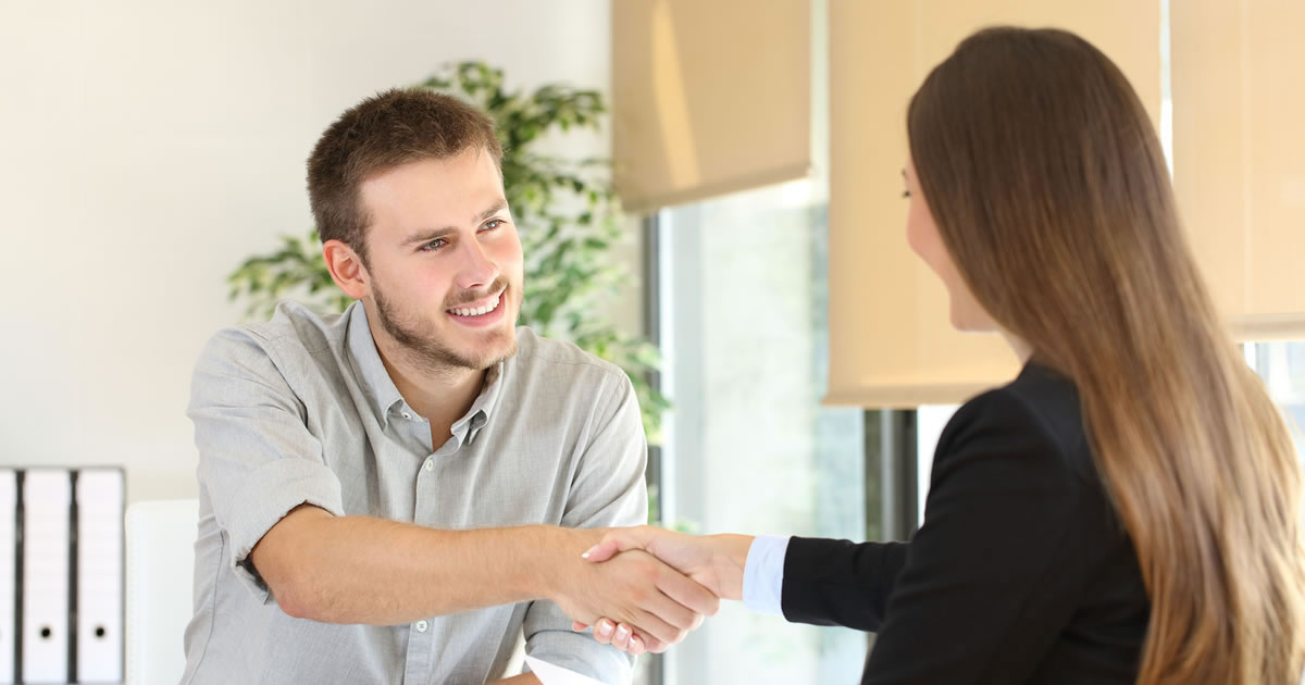 Man and woman smiling and shaking hands