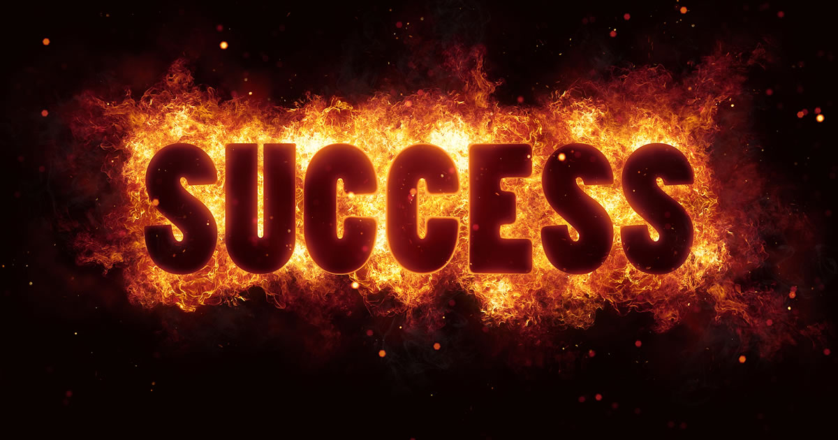 The word success in front of flames
