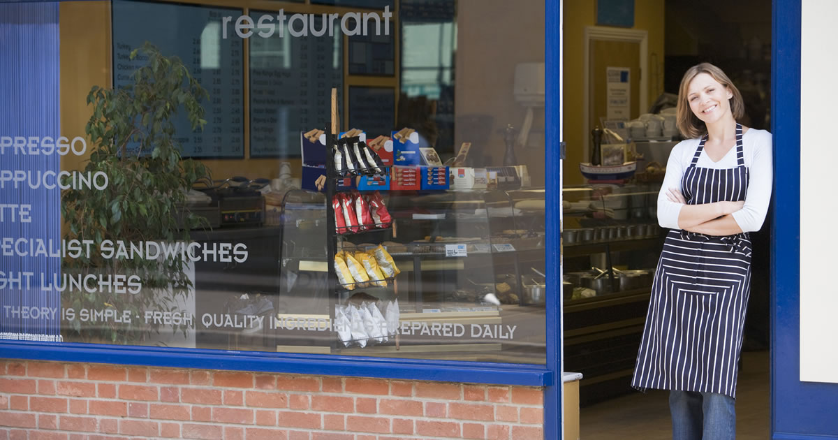 Smiling woman standing in doorway of restaurant