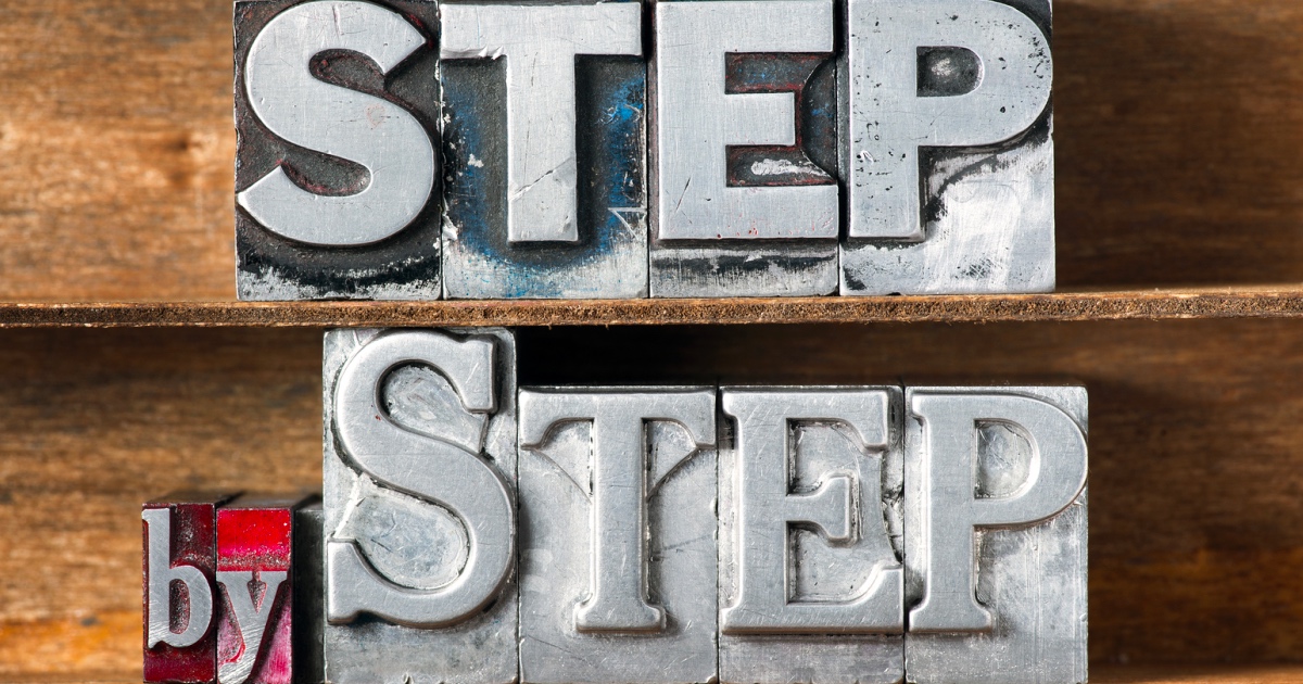 Step by step phrase made from metallic letterpress type on wooden tray