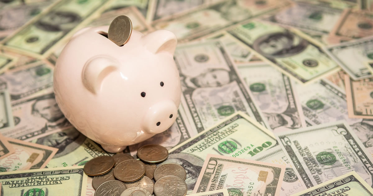 Piggy bank on background of dollar bills and American quarter coins