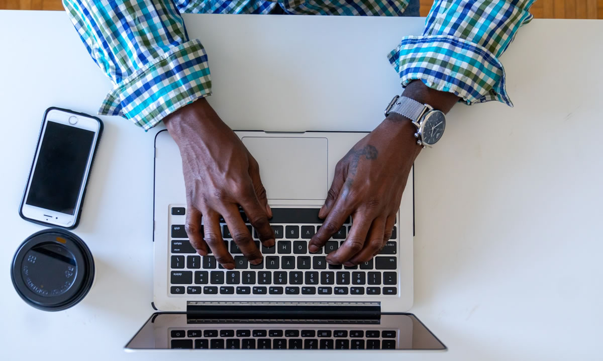 Overhead shot of man's hands working on laptop