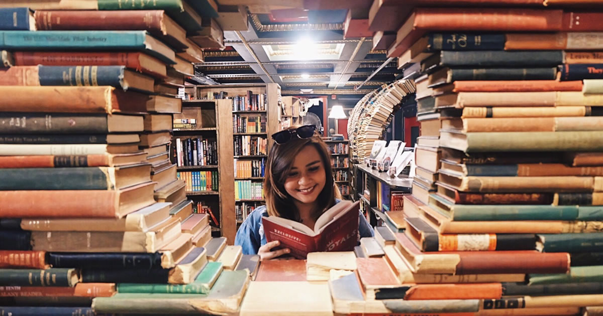 Woman surrounded by stacks of books