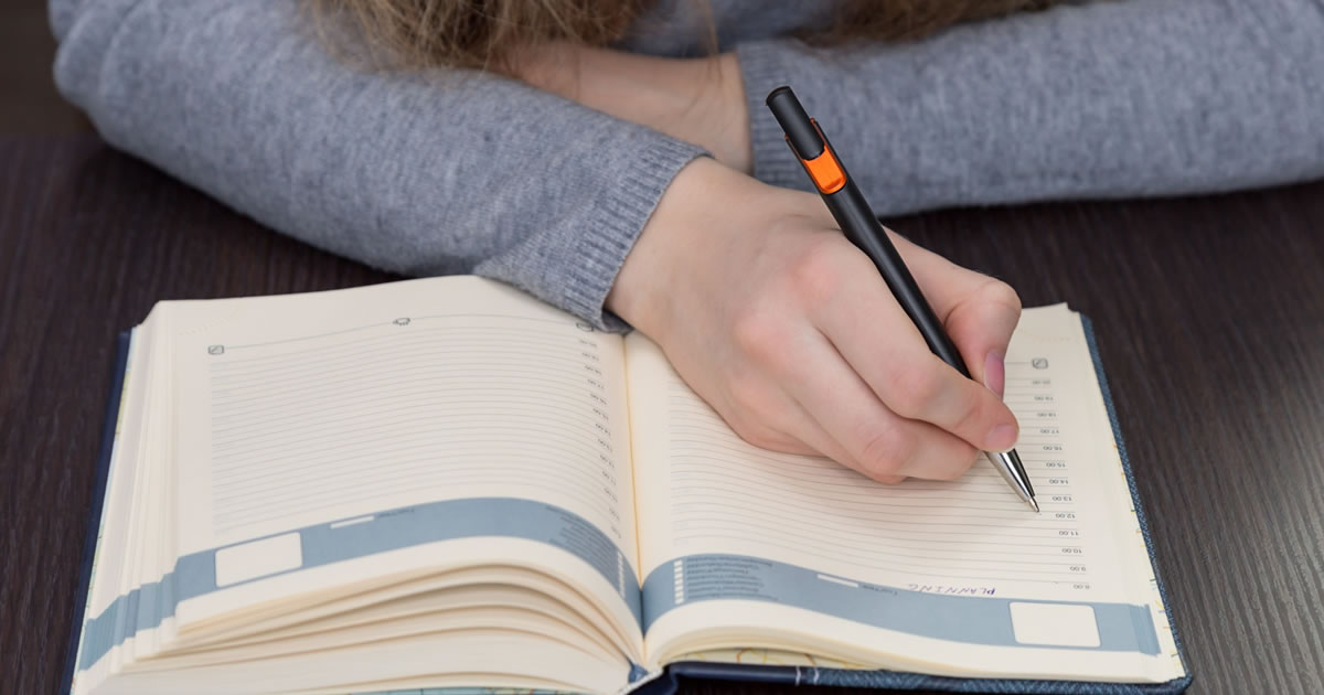 Girl writes a plan for the day in her diary