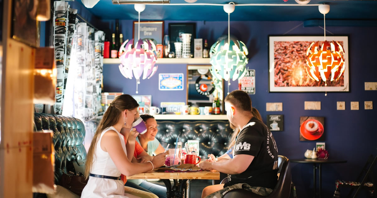 Group of smiling people sitting together at a restaurant table