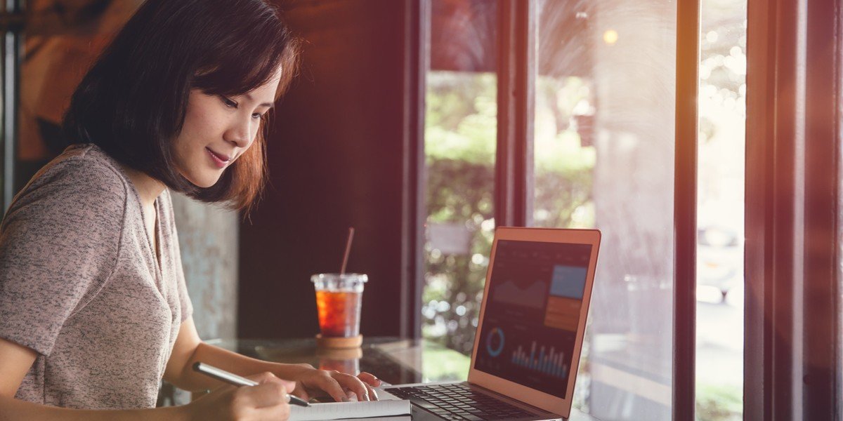 Woman working on project writing on notebook