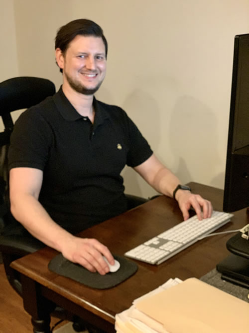 Photo of copywriter Ben Phillips sitting in front of his computer at his desk