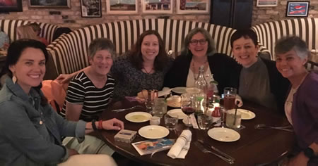 Foto do escritor Chris Allsop em uma mesa de restaurante comemorando o lançamento de um livro com outros participantes do Bootcamp 2019 da AWAI