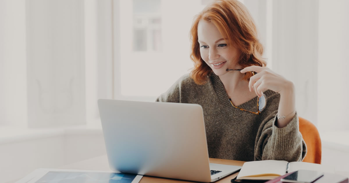 Female writer, working on laptop at table