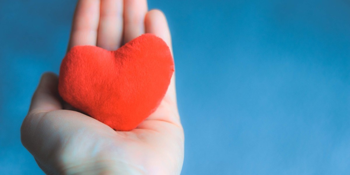 Hand holding a red heart plush