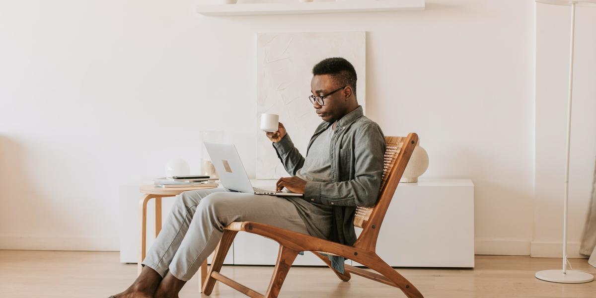 Male writer sitting in a chair with a laptop on his lap