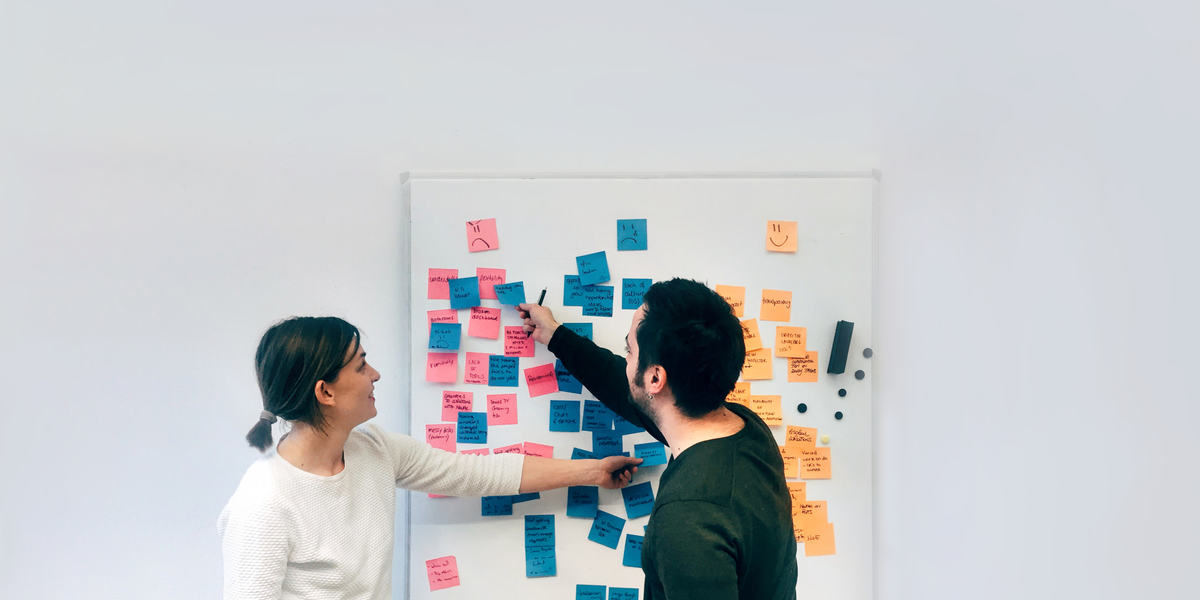 Man and woman working on board planning