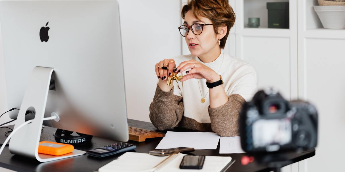 Woman looking at computer and being filmed