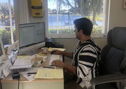 O escritor Elias Christeas trabalhando em sua mesa em casa.
