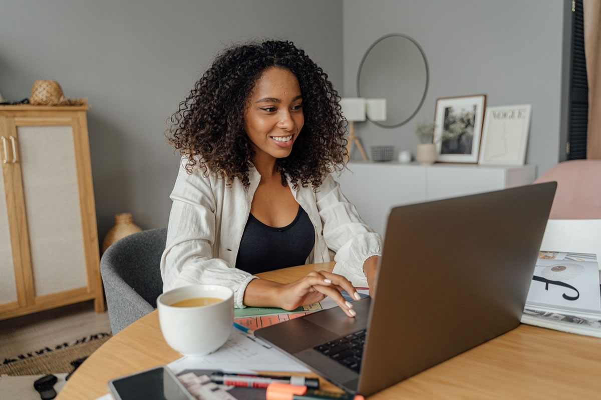 woman writing on macbook pro on a wooden table