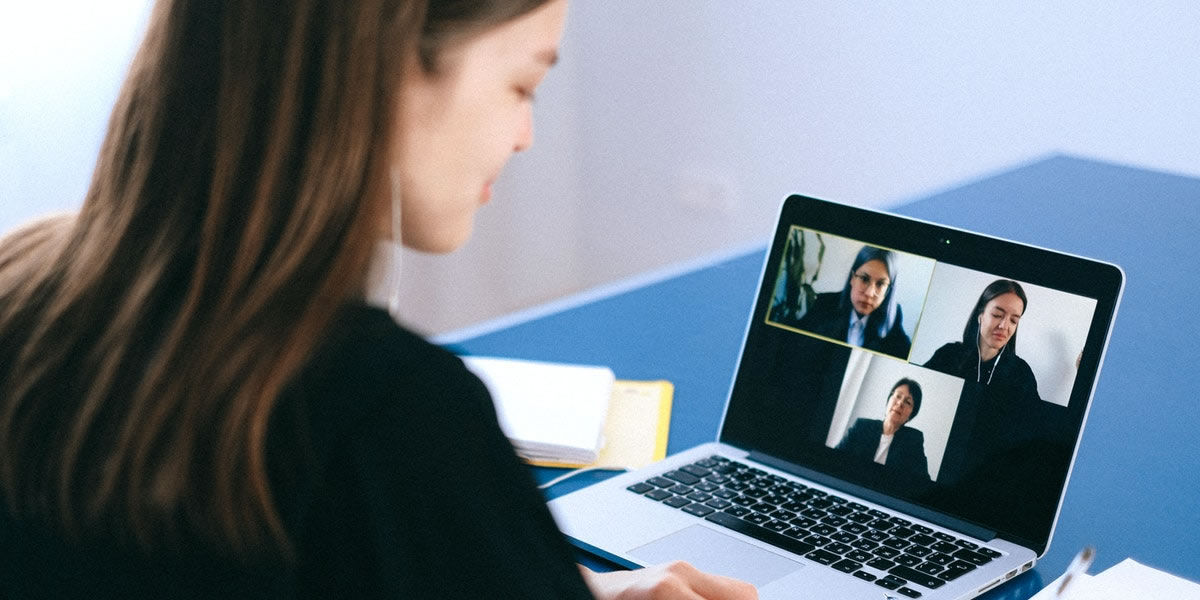 Businesswoman on a laptop on a video call with three people