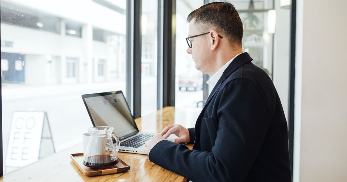 Man studying laptop in coffee shop