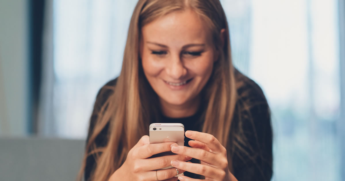 Mulher jovem enviando mensagens de texto pelo smartphone