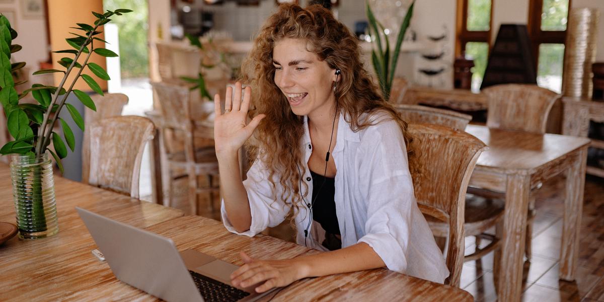 woman sitting on a chair in a video call on a MacBook laptop