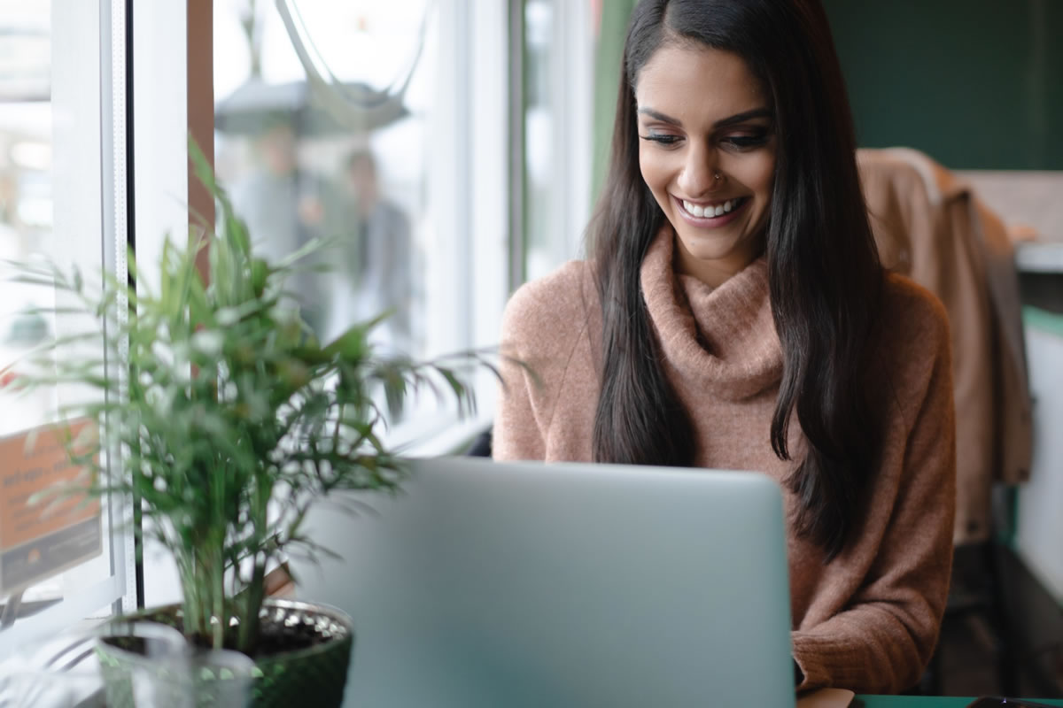 Woman at a cafe working on a laptop