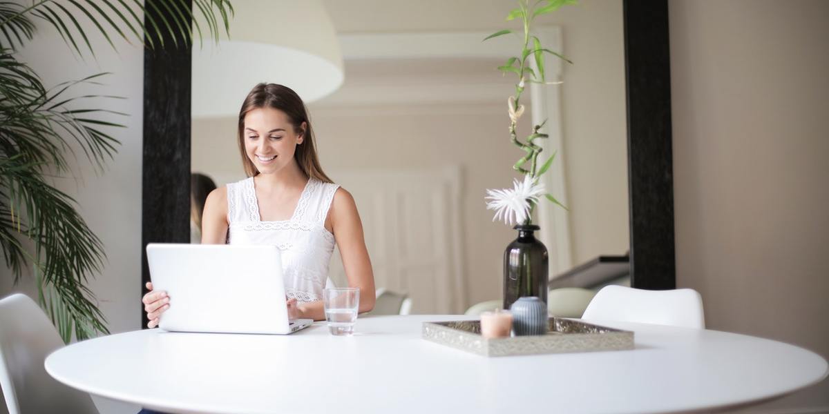 smiling young woman with laptop at table