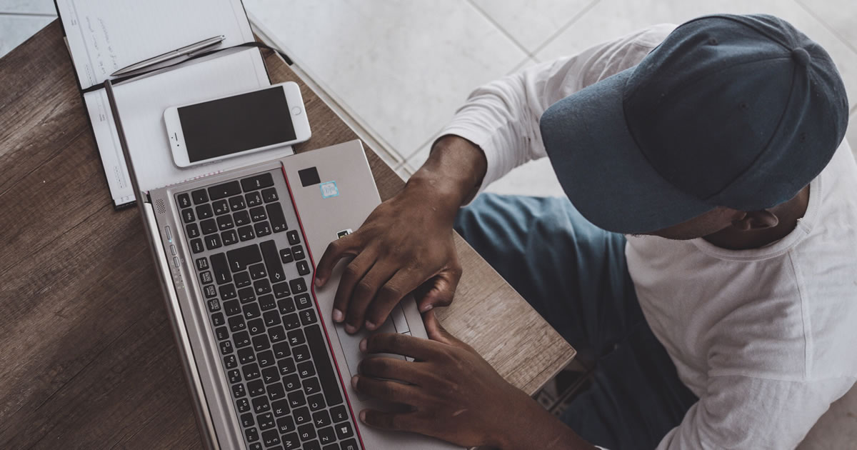 Overhead photo of man using laptop at desk