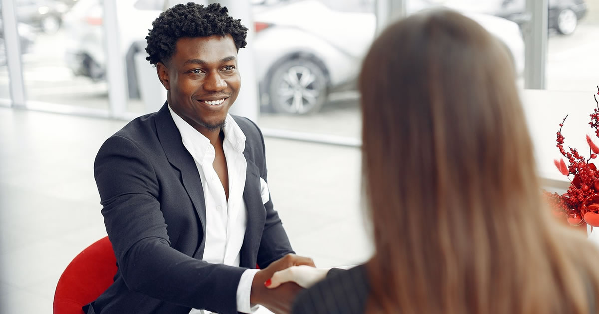 Happy young male writer shaking hands with new client