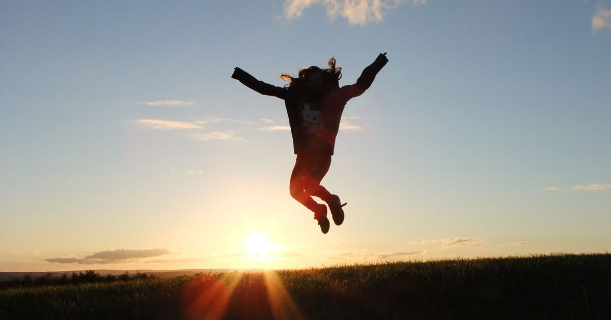 Silhouette photo of person jumping on field during the golden hour