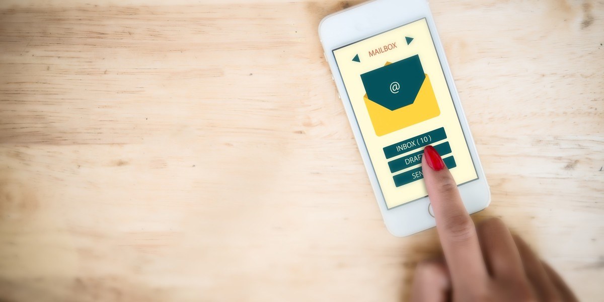 close-up of business woman’s hand checking incoming emails on mobile phone