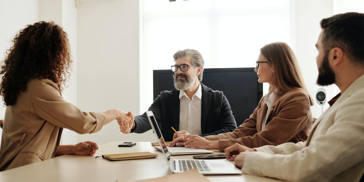 Woman getting clients and shaking hands with them