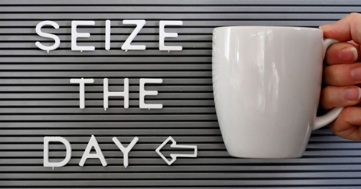 Carpe diem! A message board saying Seize the Day with a woman holding a coffee mug next to it.