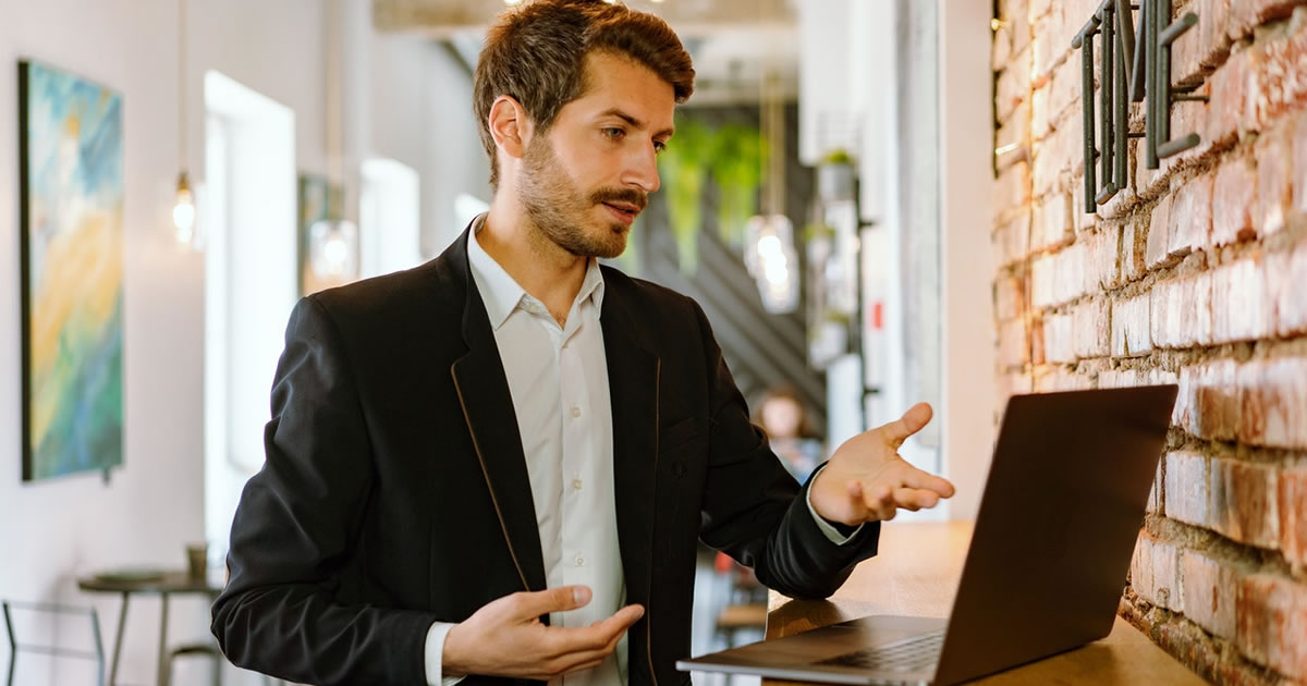 man in black suit jacket on a laptop video chat