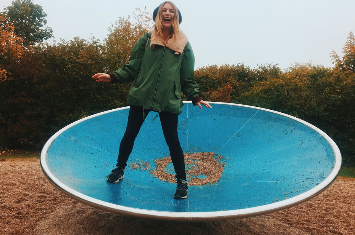 Laughing woman on spinner in playground