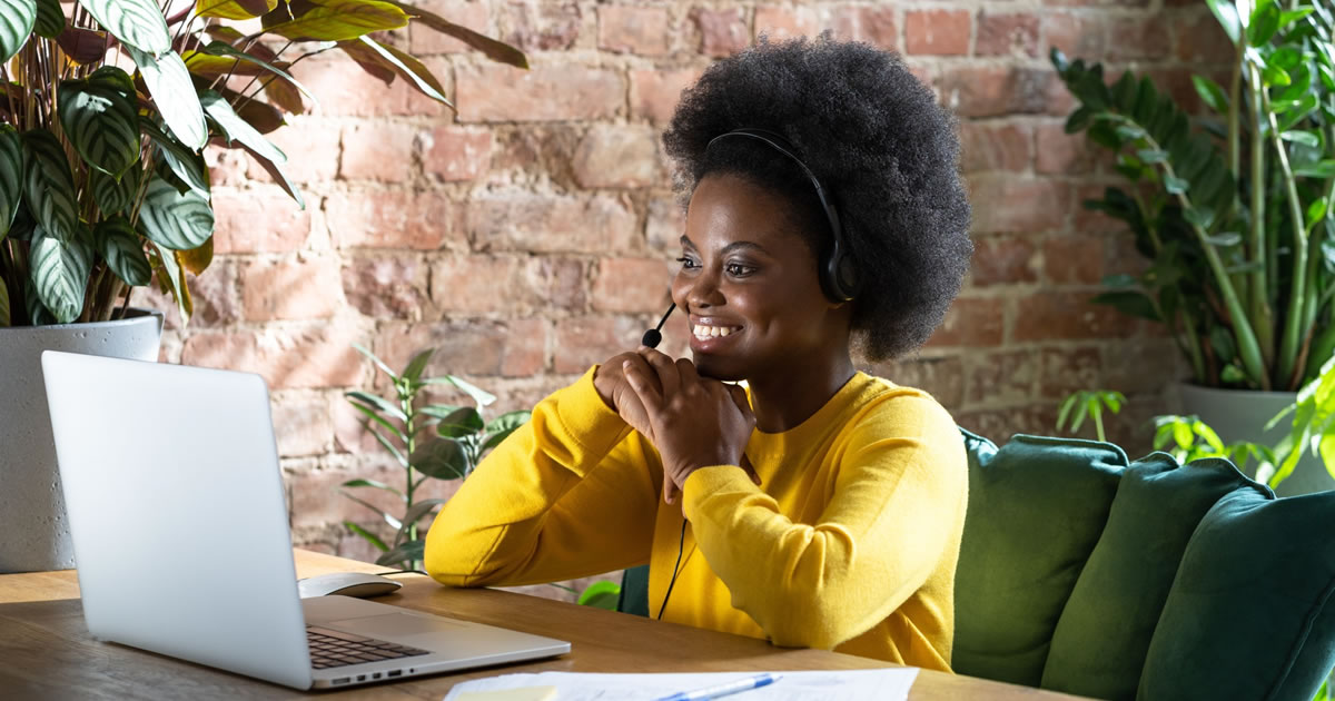 Smiling woman freelancer sitting at desk on video call