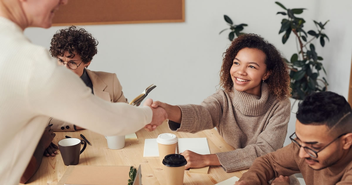 smiling female freelance writer shaking hands with a new client