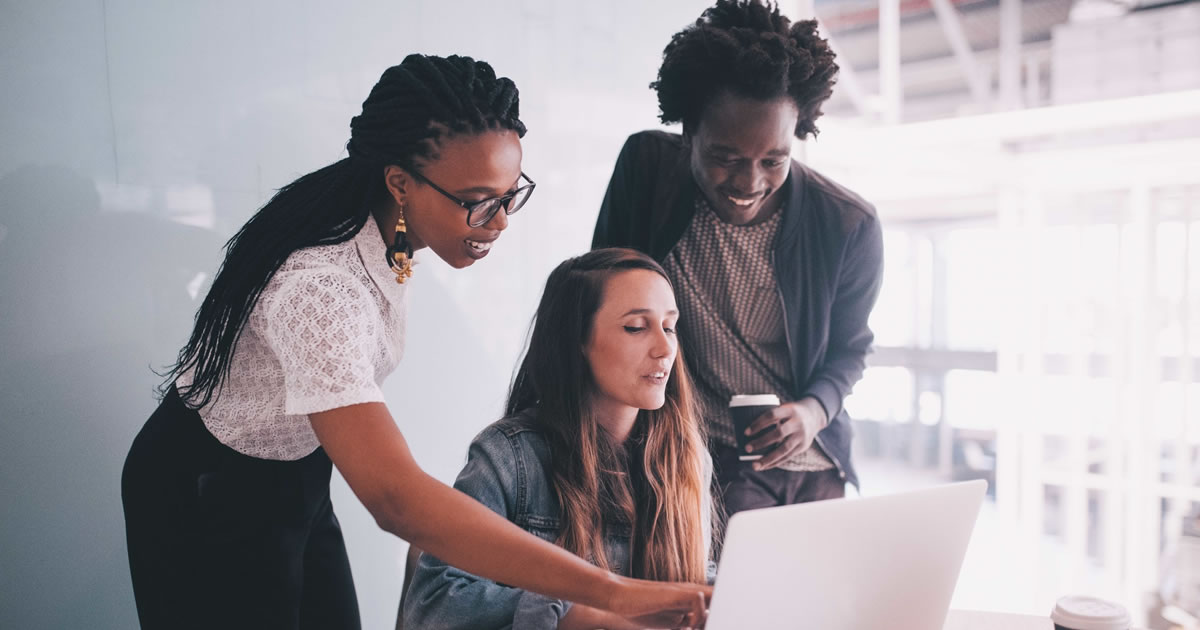 escritor e clientes analisando laptop em reunião de marketing