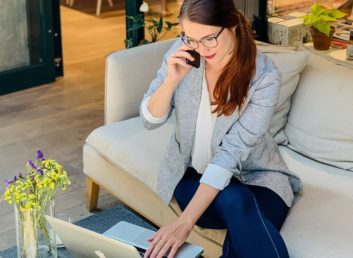 Young businesswoman working with her laptop and smartphone in a modern office