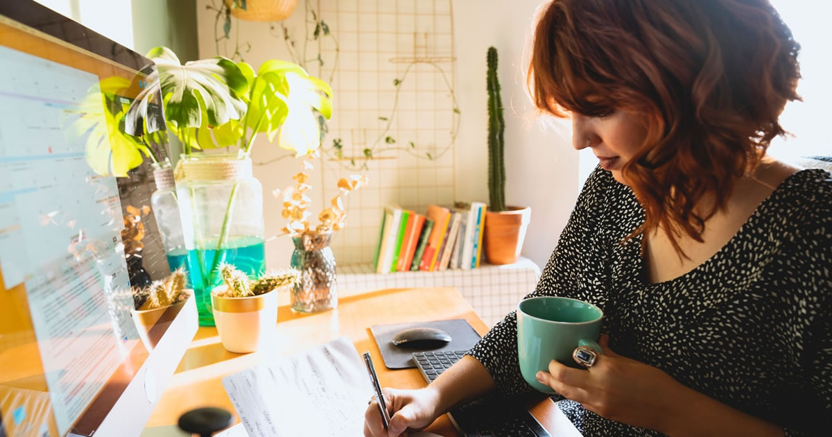 woman freelance writer planning content in her notebook with computer