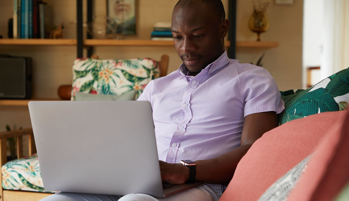 smiling woman writing on laptop at table