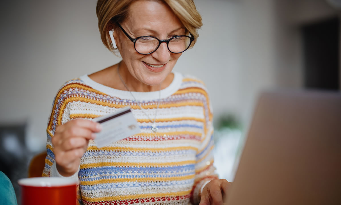 A mature woman making a purchase on her laptop