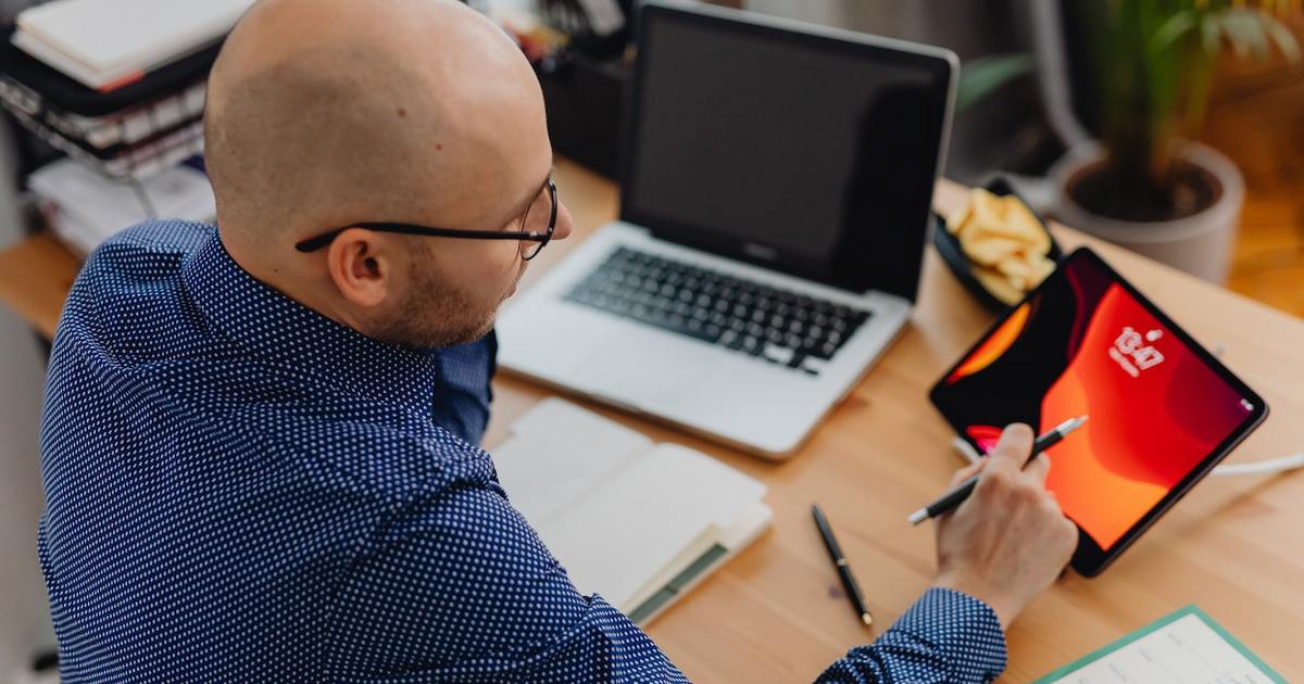 Man sitting in front of a laptop and tablet