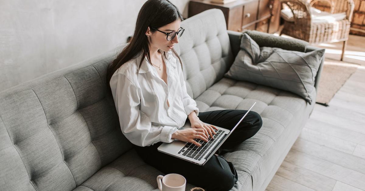 Woman typing on laptop on couch