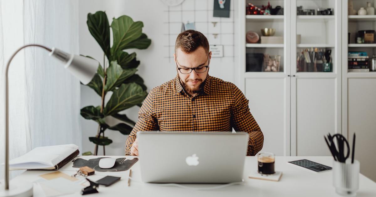 man writing on laptop in home office