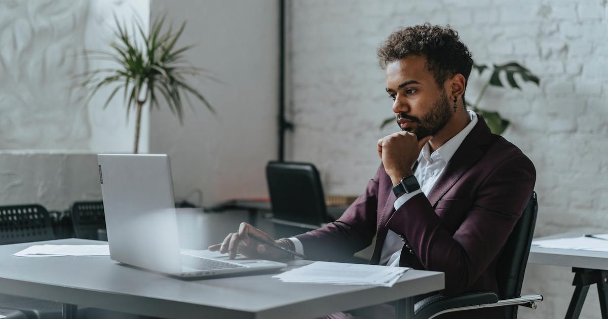 pensive male writer working on laptop at table