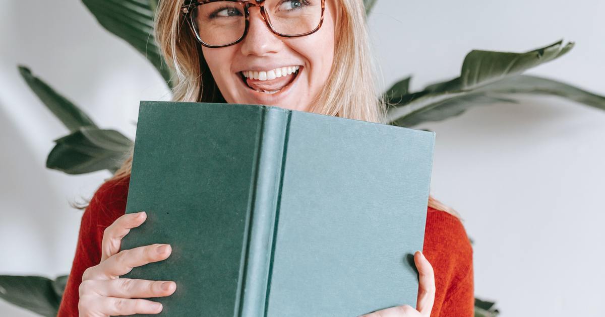 Young woman smiling holding a book