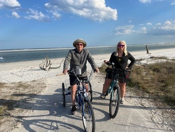 A escritora Cindy Cyr em um passeio de bicicleta na praia com seu pai