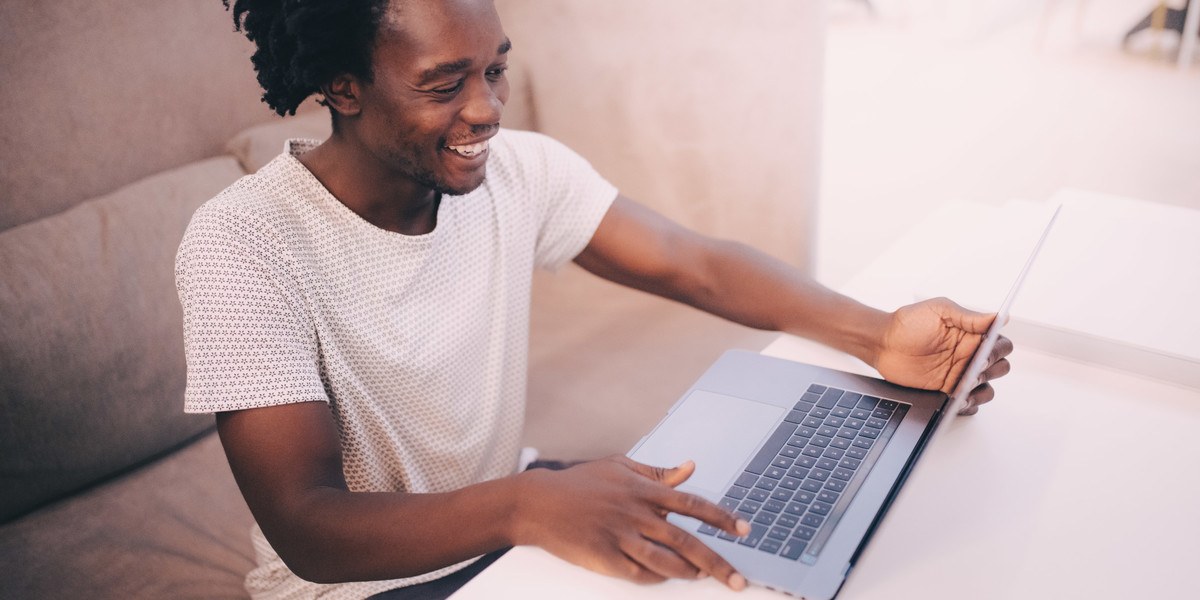 Smiling man working on laptop at table