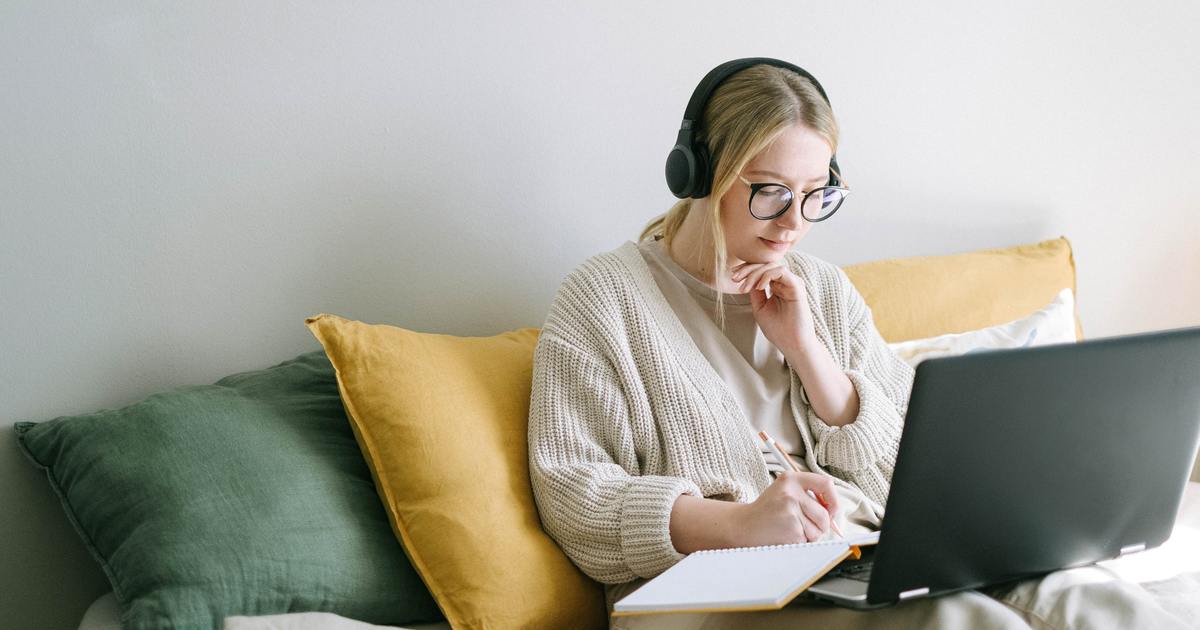 Writer sitting on the couch with laptop and headphones