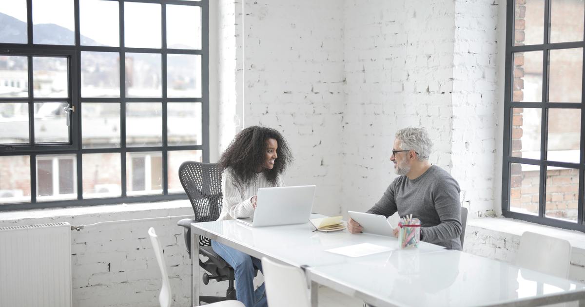 Woman smiling working on white papers with coworkers